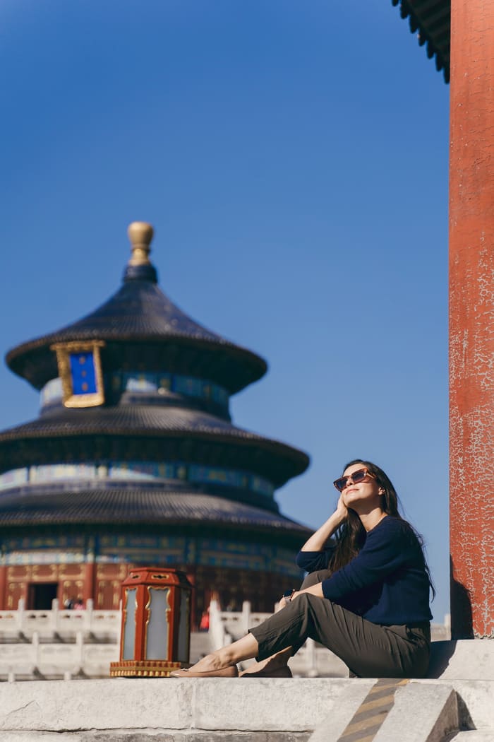 Mujer con un monumento de China al fondo